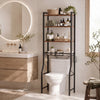 A black over-the-toilet storage shelf organizer is installed next to a vanity and toilet in a bright bathroom.