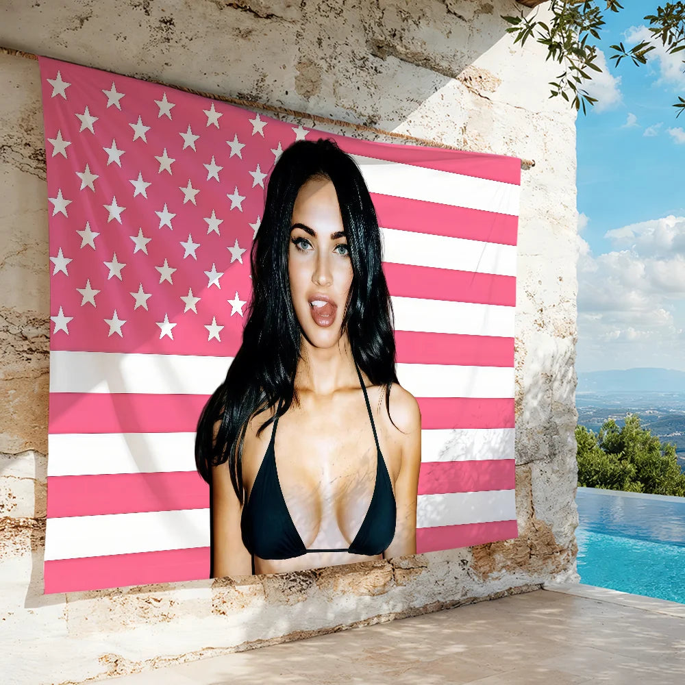 A woman posing in a black bikini is framed by a pink and white American flag banner against a stone wall.