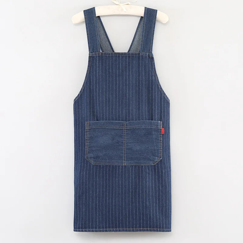 A dark blue striped denim apron hanging on a wooden hanger.