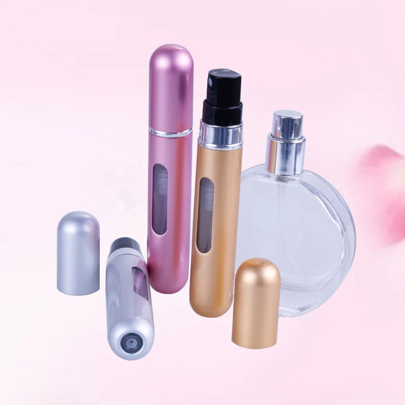 A collection of five portable refillable perfume spray bottles in various metallic shades, including pink, gold, and silver.