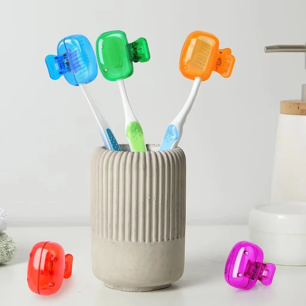 A collection of colorful reusable toothbrush head covers, including blue, green, and orange silicone caps, are displayed in a