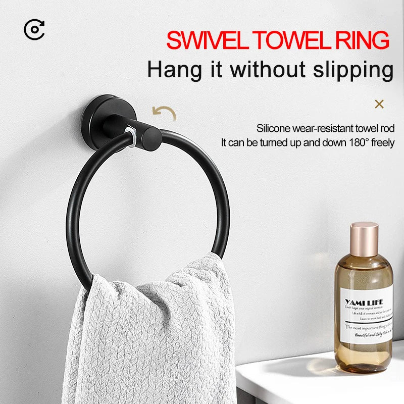 A black swivel towel ring is mounted on a white wall, with a gray towel hanging below it.