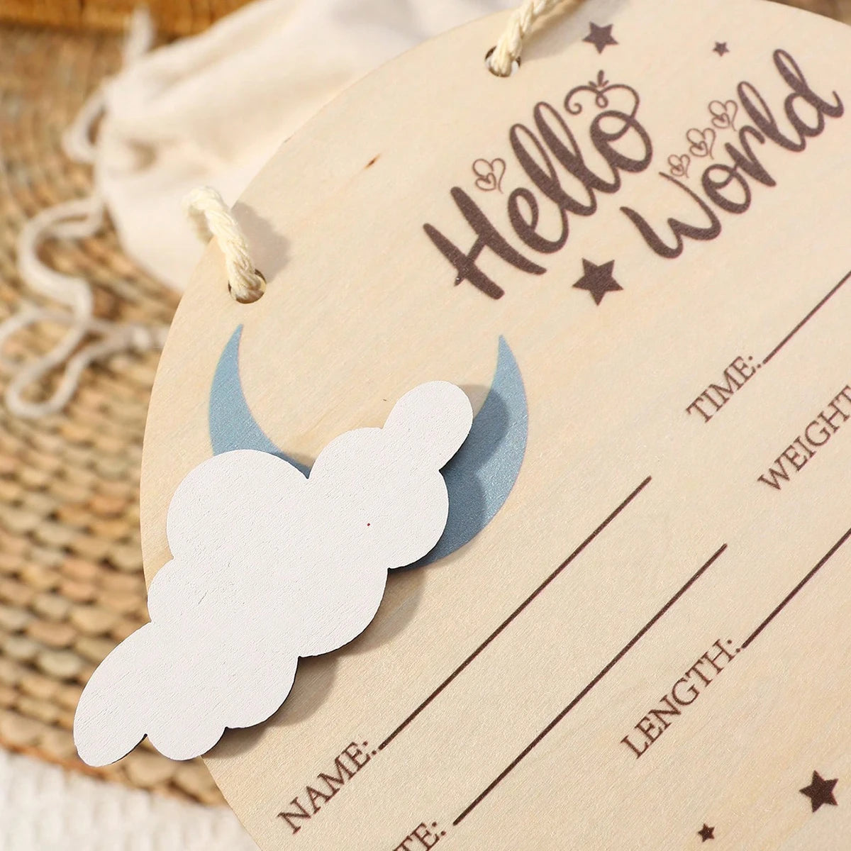 Atrezzo de madera con el texto Hello World y líneas para detalles del bebé, con un recorte de nube.