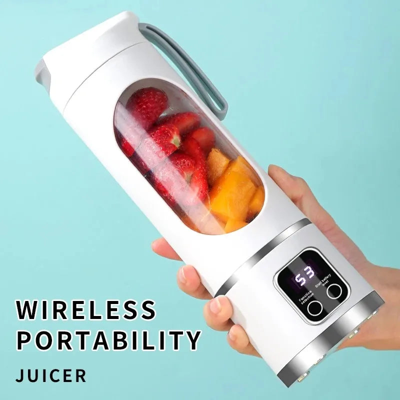Una mano sostiene una licuadora eléctrica portátil blanca llena de fresas y segmentos de naranja.