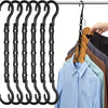 A multi-pack of black plastic clothes hangers hanging on a wire, with several shirts displayed below.
