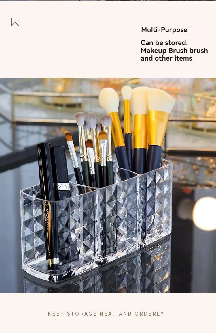 Clear acrylic multi-purpose makeup brush holder with three compartments for storing brushes and other items.