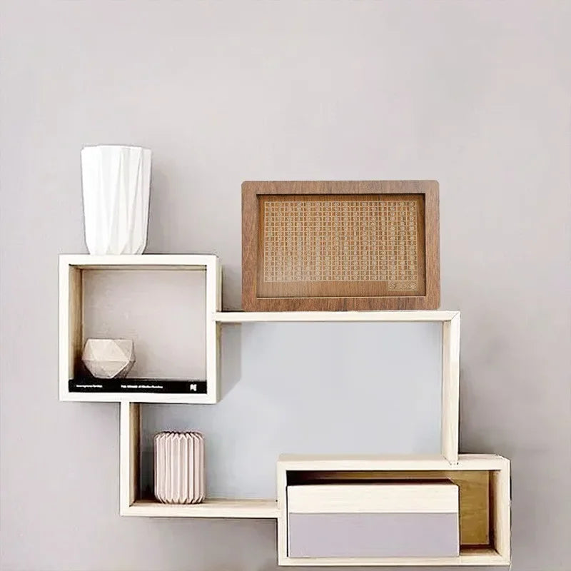 A set of wooden storage boxes and a white cylindrical container displayed on a light gray wall.