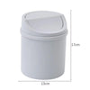 A white compact desktop trash can with a flip-top lid, shown from the side.