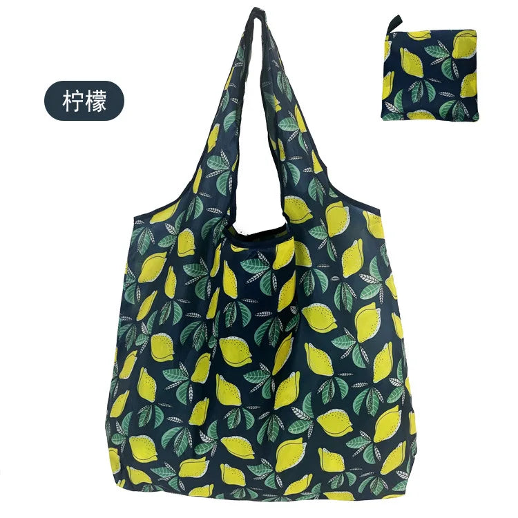 Wiederverwendbare Einkaufstasche mit dunkelblauer Grundfarbe und gelb-grünen Blattmustern.