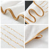Close-up shots of a white coral fleece towel with delicate gold stripe detailing on the edge.