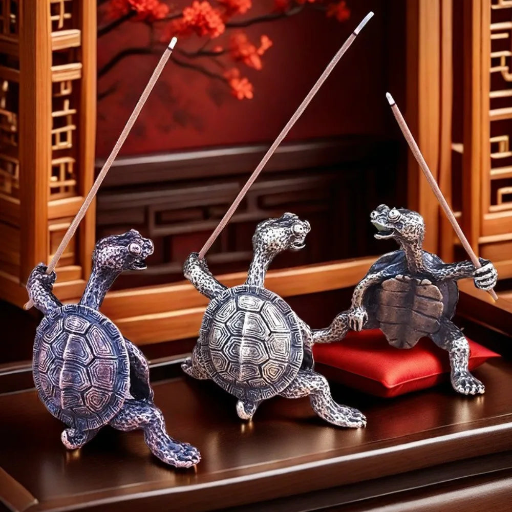 Un ensemble de trois petites figurines de tortue en métal utilisées comme supports d'encens pour la méditation et la décorati