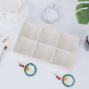 A velvet jewelry organizer tray with drawers displaying various beaded and gemstone jewelry items.