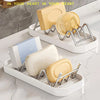 A white stainless steel rack holds four yellow and cream-colored W-shaped soap containers.