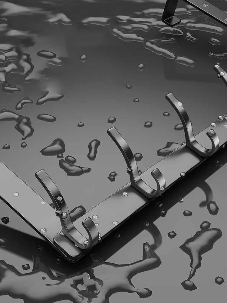 A close-up view of a black over-the-door organizer rack with extended arms resting on a dark, reflective surface.