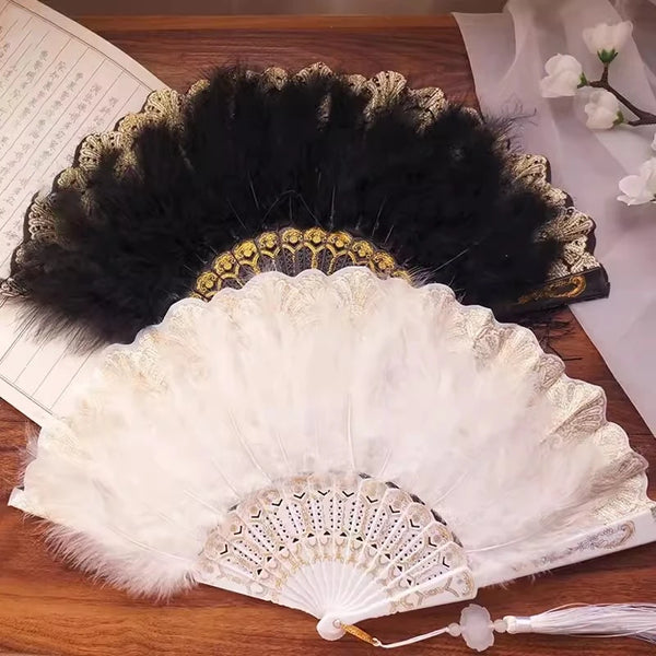 A vintage folding hand fan with white and gold accents is displayed on a wooden surface.
