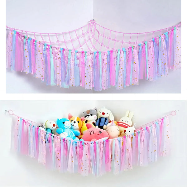 A colorful bohemian stuffed animal hammock featuring pink, blue, and purple fabric streamers.