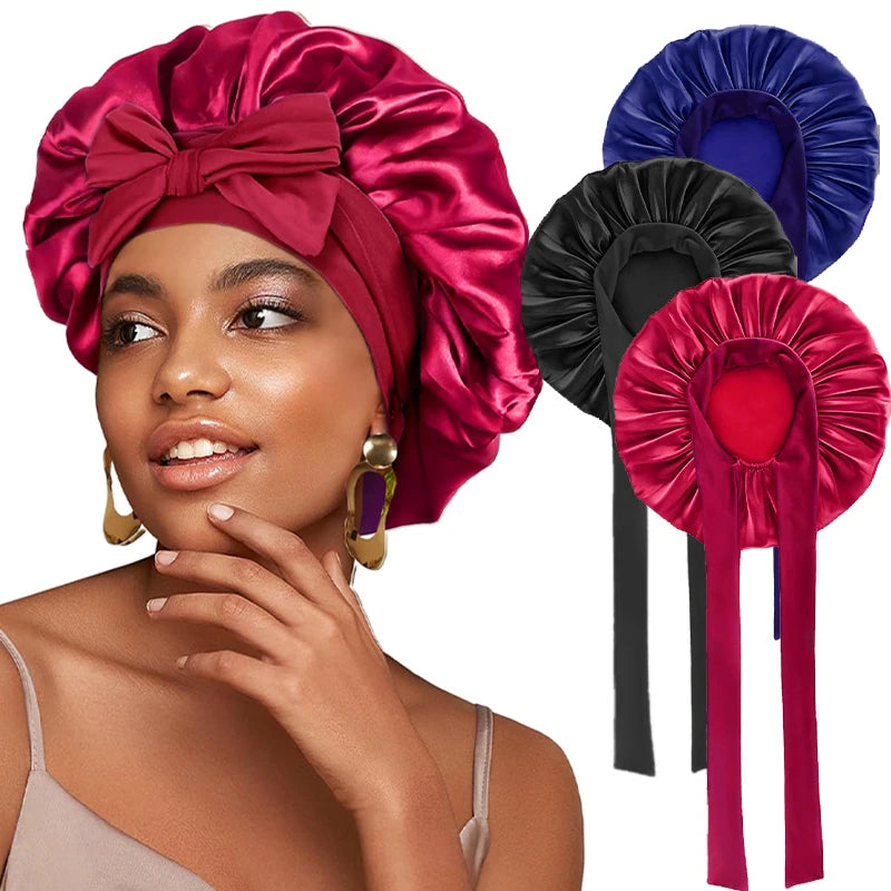A woman models a vibrant magenta satin sleeping cap with an adjustable tie band and matching fabric accessories.