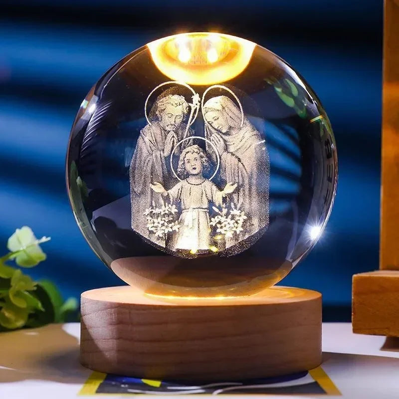A clear glass crystal ball with a glowing interior displaying religious figures.