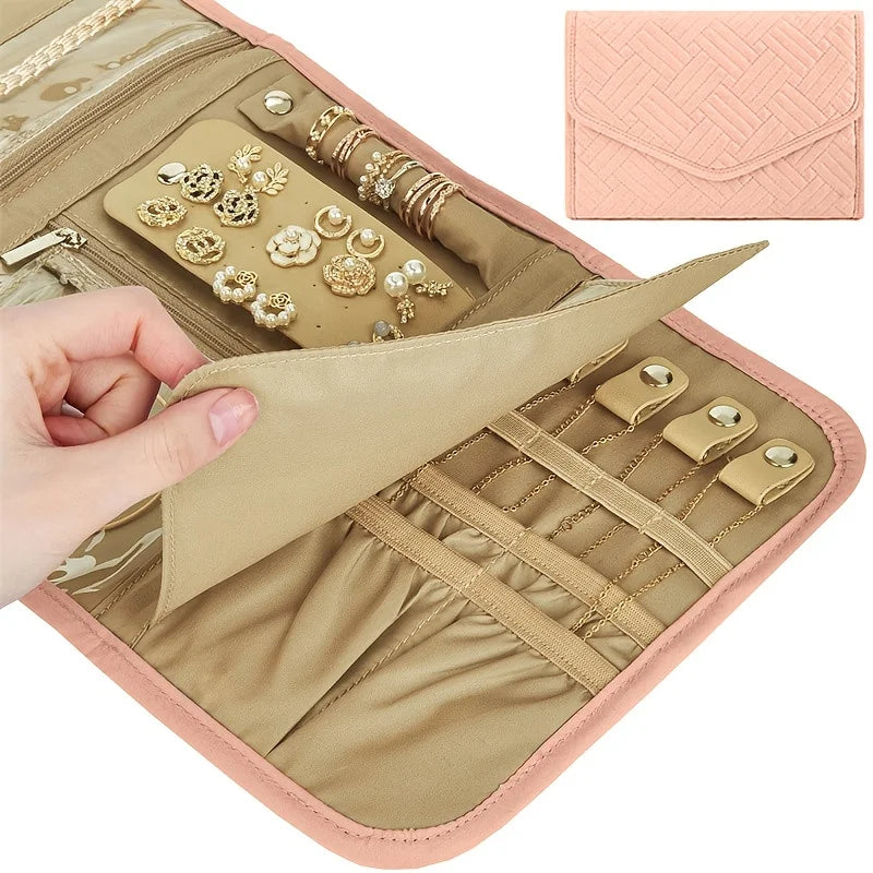 A beige foldable waterproof jewelry organizer bag showing various gold and silver jewelry pieces inside.
