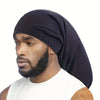A man wearing a black satin hair bonnet with a beard, looking to the side.