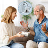 A smiling woman gives a heart-shaped acrylic keepsake plaque to an older man during Father's Day.