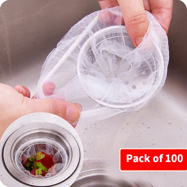 A hand is holding a clear mesh strainer bag filled with small, round mesh strainers for kitchen drains.