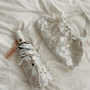 A white full-automatic embroidered sun umbrella is shown lying on a white sheet.