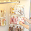 A white multi-clip drying rack displays various folded fabric items like t-shirts and accessories for laundry.
