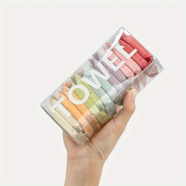 A hand holds a clear plastic container filled with various colored disposable compressed washcloths for facial cleansing.
