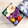 A dark tray holds various natural crystal stones including quartz, jade, amethyst, and citrine for meditation and decor.