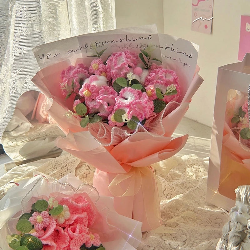 Bouquet de fleurs de carnation roses et faites main, emballé dans du papier transparent et un ruban.