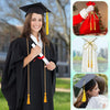 A smiling woman in a black graduation gown holds an honor cord with yellow tassel ends.