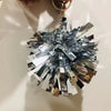 Silber- und goldfarbener metallischer Konfetti-Pom-Pom-Anhänger mit Kette.