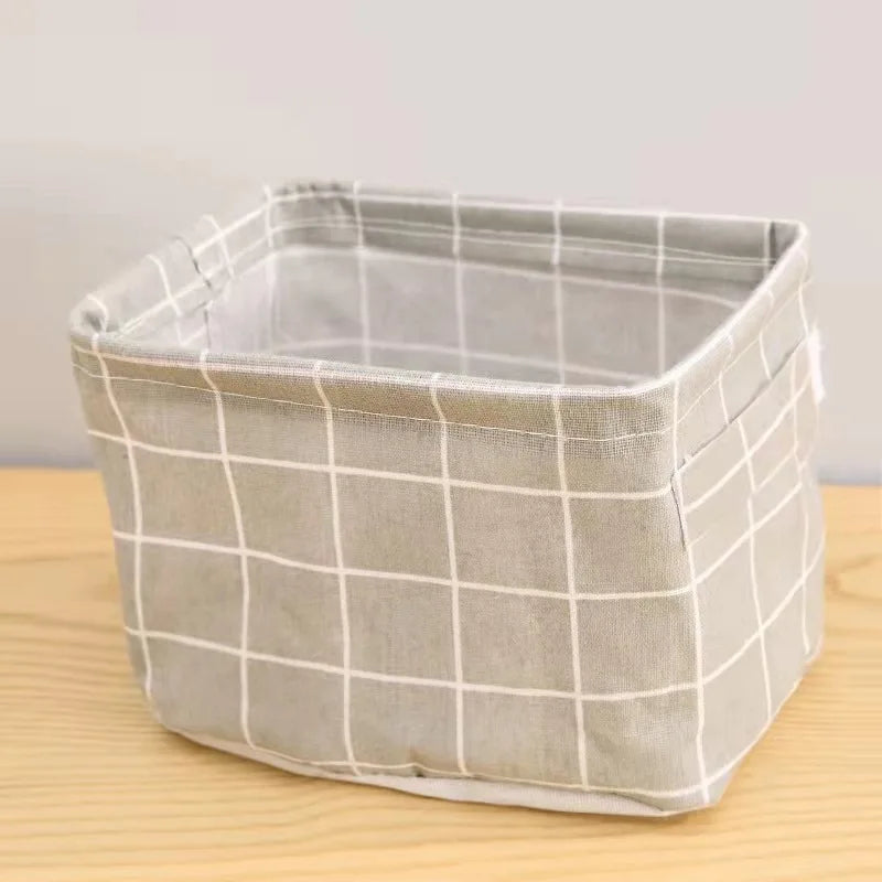 A light beige cotton and hemp storage basket with a grid pattern sitting on a wooden surface.