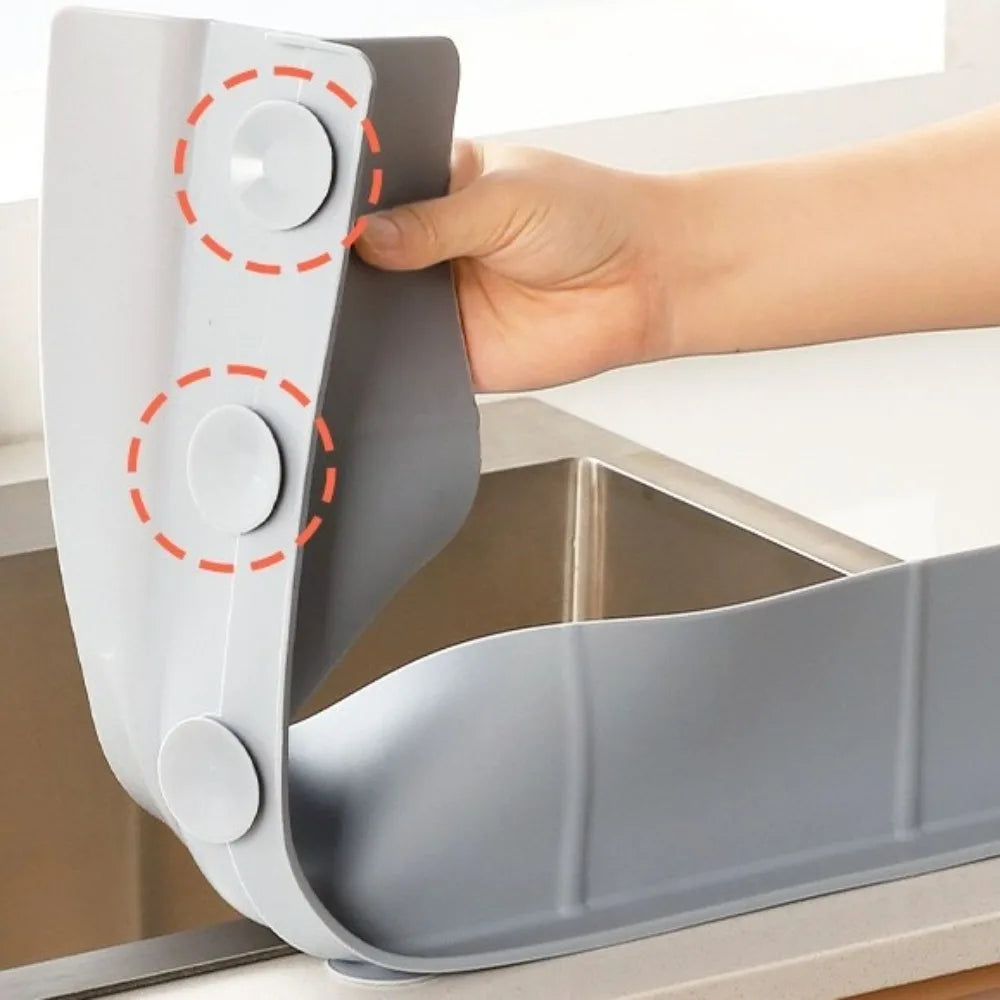 Eine Hand installiert eine Silikon-Abdeckung zum Schutz der Küche auf eine Edelstahlspüle.