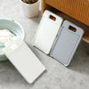 A set of three white and gray fabric washing boards are displayed on a light surface next to a wooden shelf.