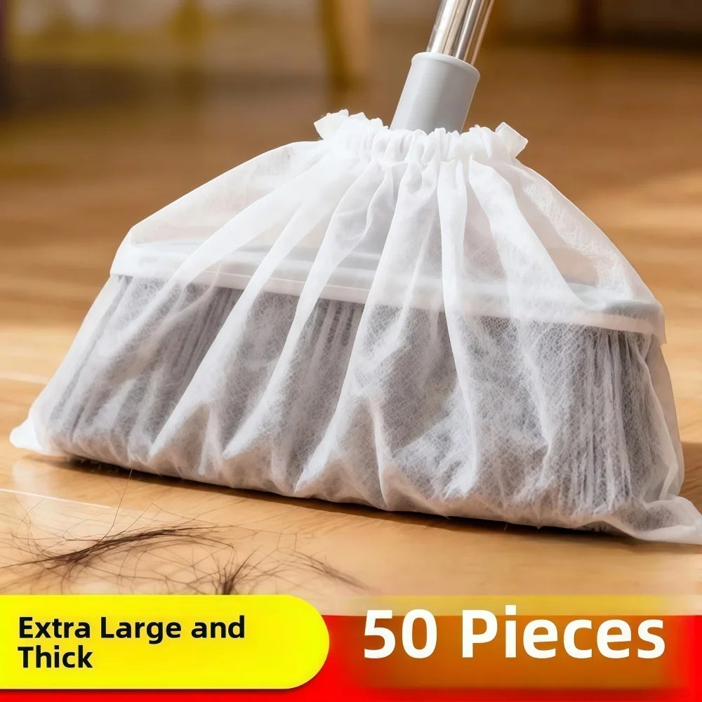 A white disposable electrostatic broom cover bag filled with light gray fibrous material, shown on a wooden surface.