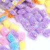 A collection of colorful laundry fragrance beads in purple, yellow, and pink are shown packaged in clear plastic.