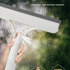 A hand is using a white spray bottle with an integrated wiper for fine water dispensing on a glass surface.