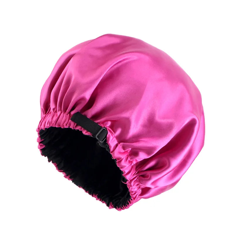 A bright pink satin sleep cap with a black lining, designed for curly and natural hair.