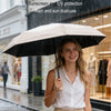 A woman holding a black umbrella in the rain, demonstrating sunscreen and UV protection for dual use.