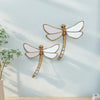 Golden dragonfly mirror wall decor featuring a detailed, gilded dragonfly design on a light blue wall.