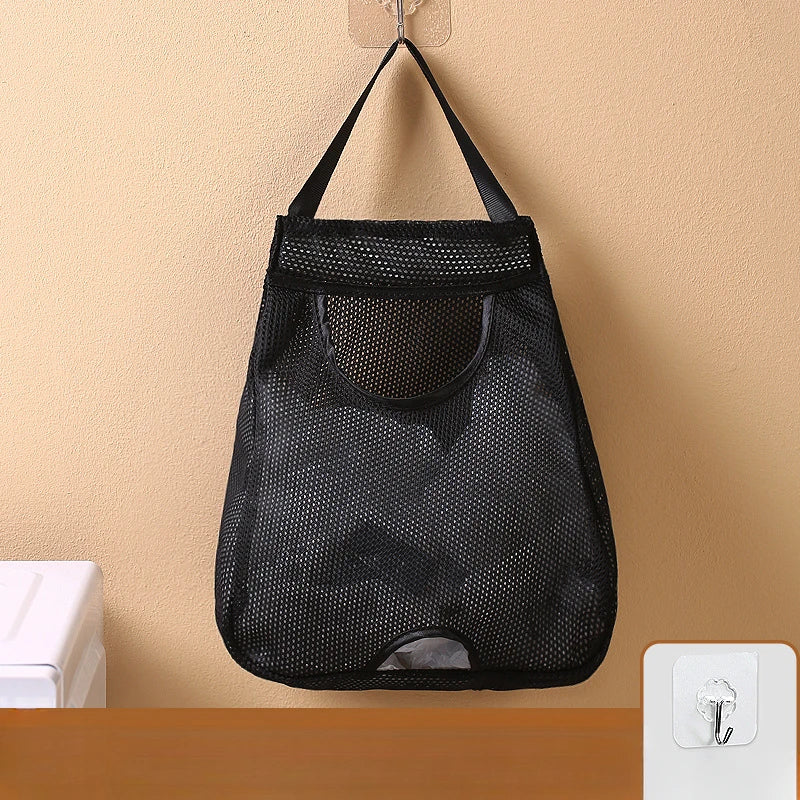 Black mesh wall mounted garbage bag storage organizer hanging on a beige wall.