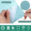 Eine Hand hält ein dünnes, weißes Material, das zwischen grünem Papier und einer wasserdichten PE-Membran liegt.