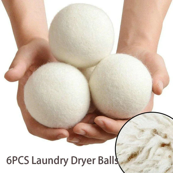 Six white wool dryer balls held in hands, showing the texture of the product.