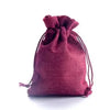 Eine tiefmagenta handgefertigte Geschenktasche aus Jute und Leinenstoff.