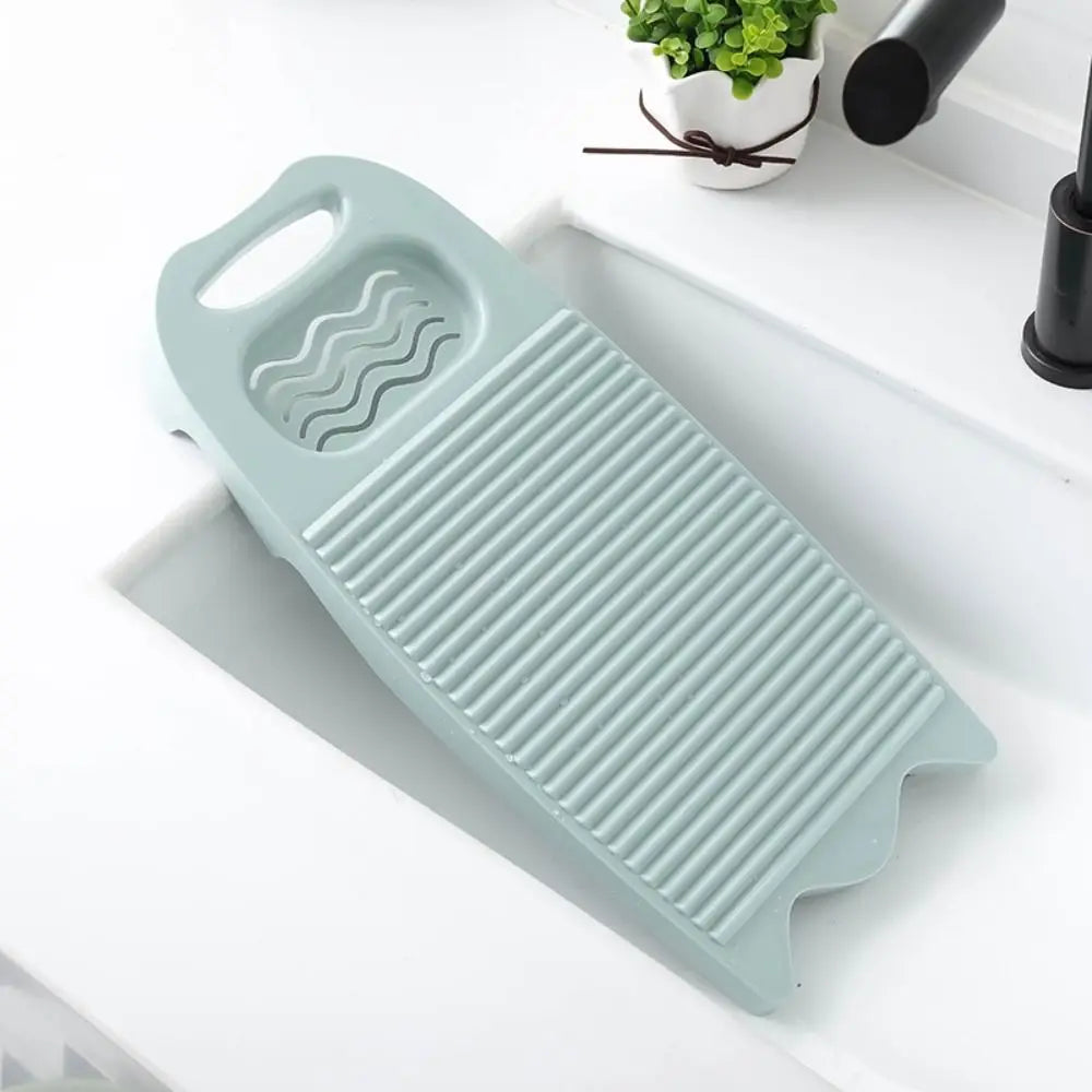 A light blue plastic washing board with a wavy handle and ribbed surface is placed on a white tray.