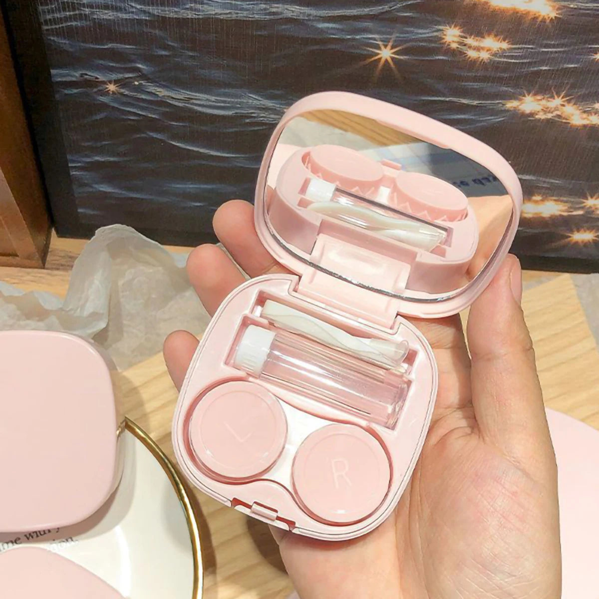 Eine pinke Macaroon-Kontaktlinsenaufbewahrungsbox ist geöffnet und zeigt Fächer zum Aufbewahren von Kontaktlinsen.