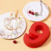 Red silicone number 9 cake mold and white plate with red cherries
