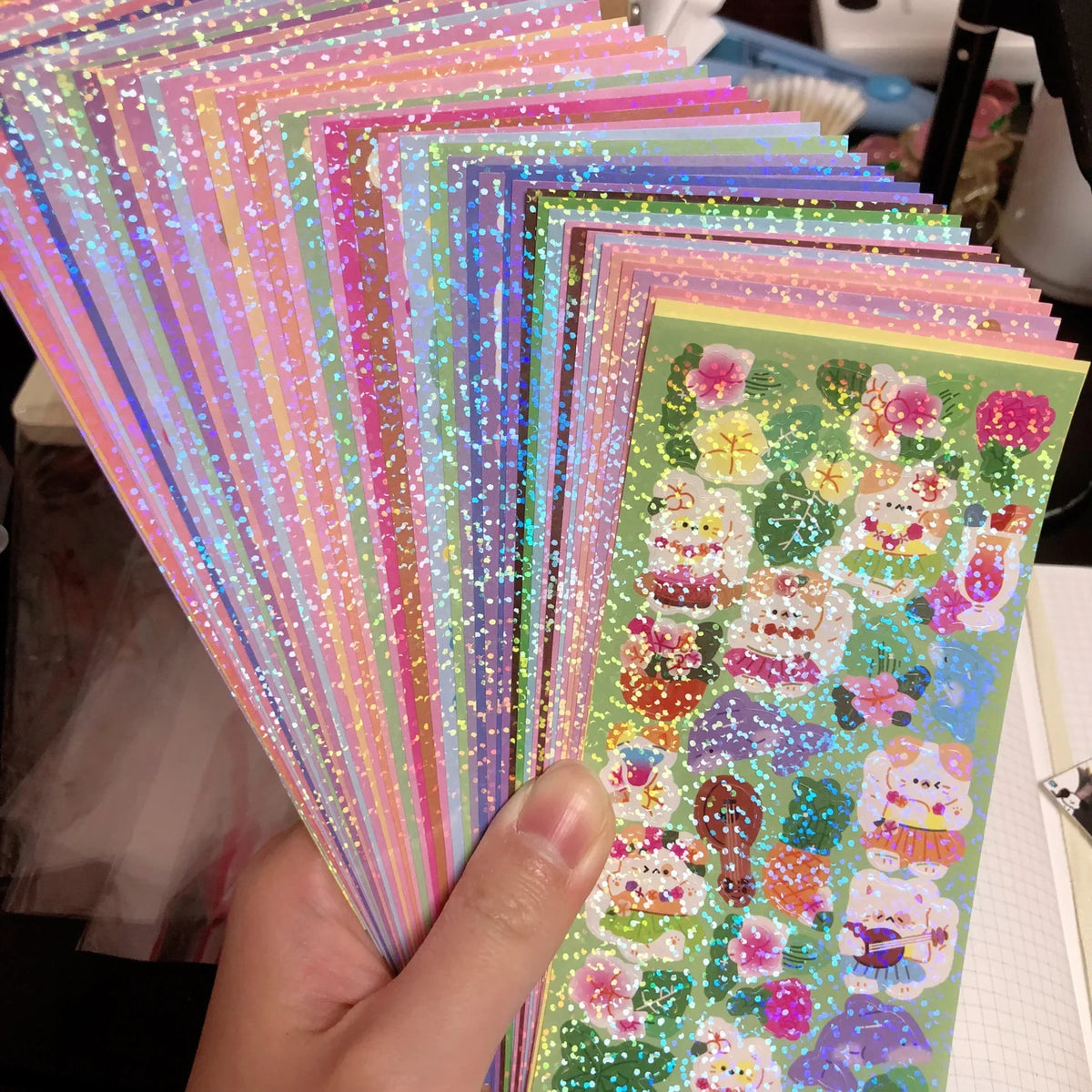 A hand holds a stack of colorful Kawaii DIY stickers for crafting and decoration.
